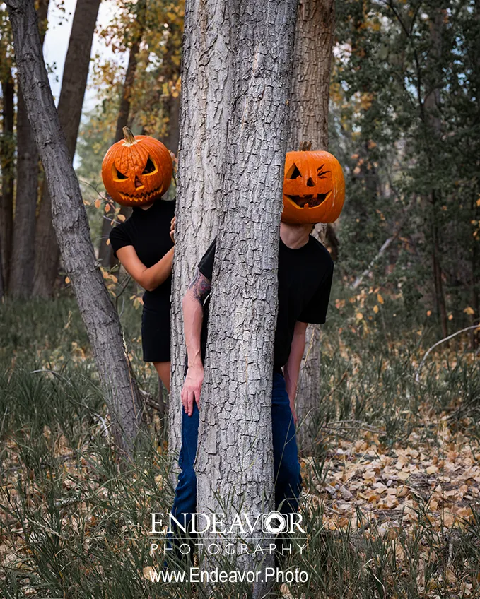 couple posing at Dixon Reservoir in Fort Collins with pumpkin on heads
