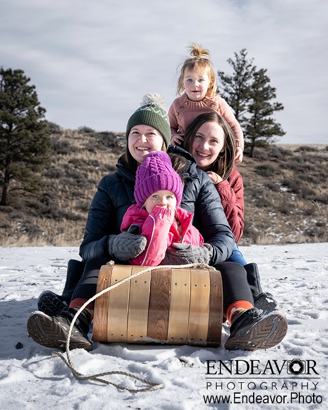 photograph of family on sled in snow
